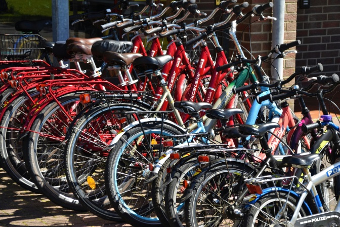 Viele Fahrräder nebeneinander an einem Fahrradständer angeschlossen.
