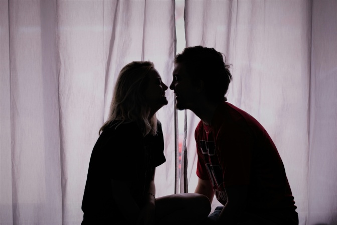 Ein Mann und eine Frau küssen sich. Man sieht nur ihre Umrisse im Gegenlicht.