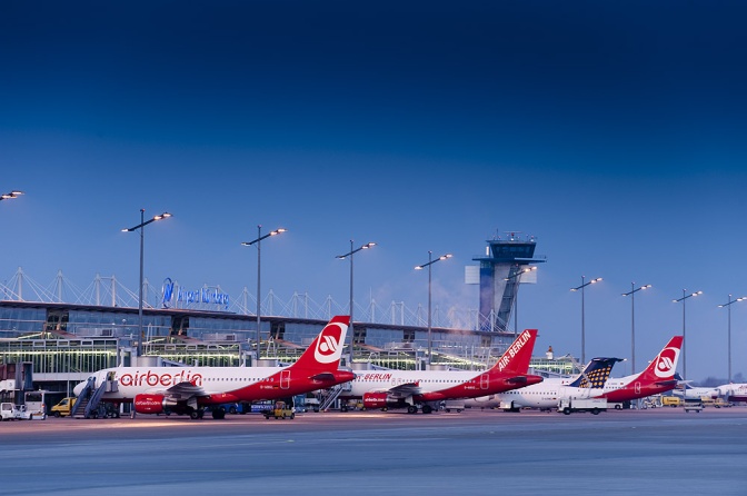 Drei rot-weiße Flugzeuge von Air Berlin stehen am Flughafen auf dem Rollfeld.