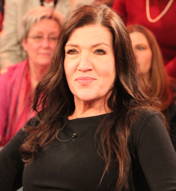 Katy Karrenbauer mit langen, glatten braunen Haaren in einem schlichten schwarzen Pullover.