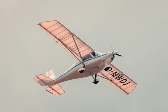 Ein kleines, leichtes Flugzeug mit rosafarbenen Flügeln.