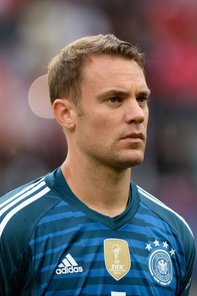 Manuel Neuer mit kurzen, dunkelblonden Haaren in einem blau gestreiften Trikot.