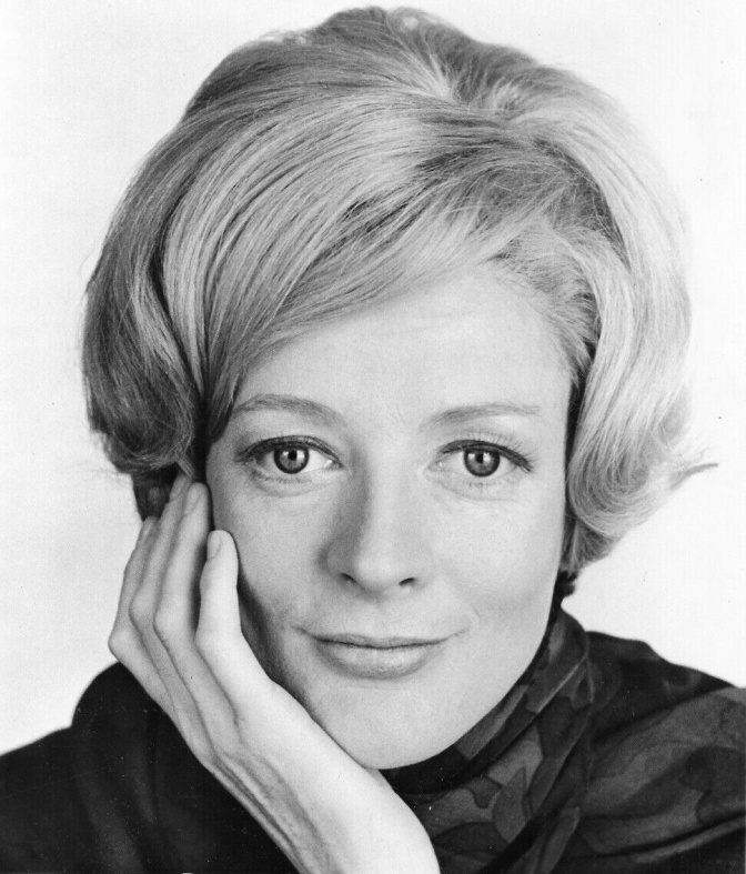 Schwarz-weiß Foto der Jungen Maggie Smith. Sie schaut direkt in die Kamera und stützt ihren Kopf in die Hand.