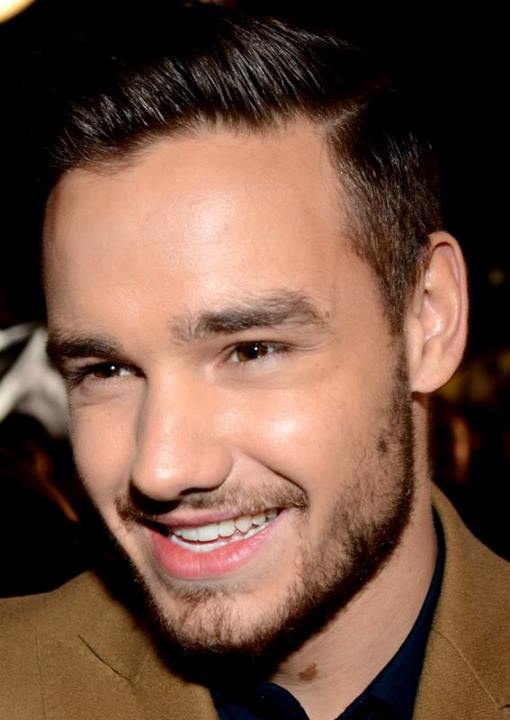 Liam Payne mit braunen Haaren und Dreitagebart. Er schaut seitlich an der Kamera vorbei.