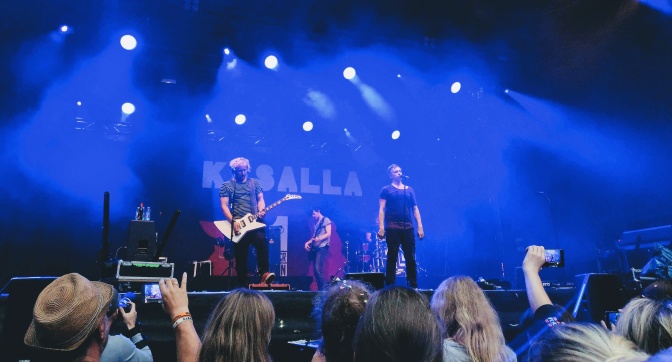 Die Band Kasalla auf einer blau beleuchteten Bühne.