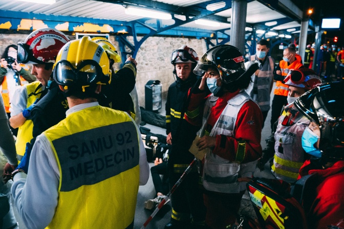 Rettungskräfte mit Helmen besprechen sich.