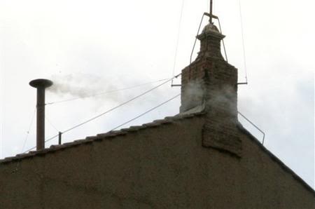 Ein kleiner, schmaler Schornstein, aus dem dünner, weißer Rauch kommt.