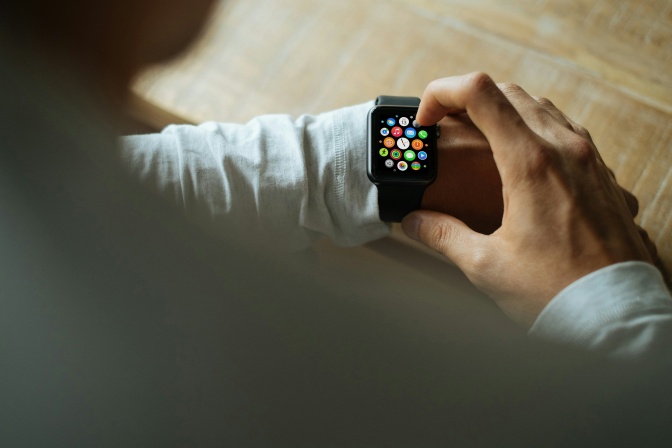 Ein Mann bedient eine Apple Watch an seinem Handgelenk.