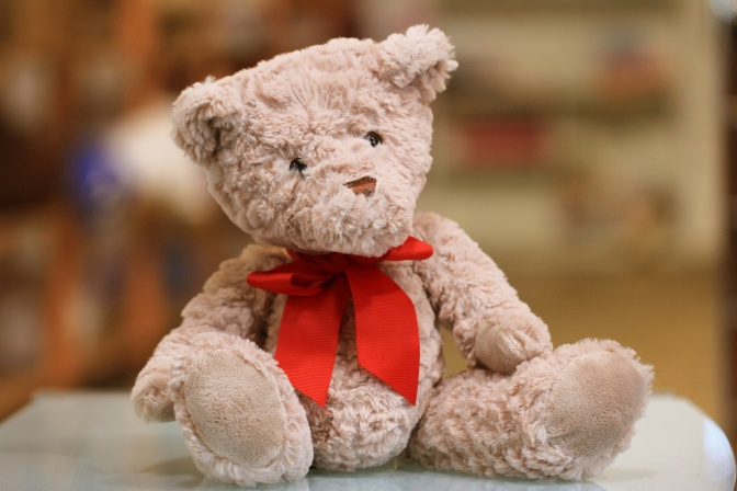 Ein heller Plüschbär mit roter Schleife