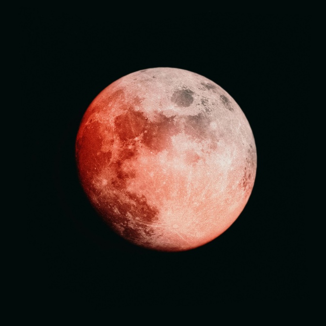 Ein Vollmond, der in Teilen hellrot leuchtet.