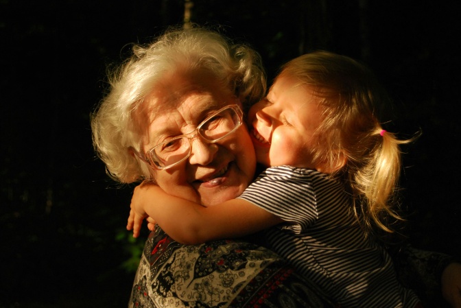 Ein kleines Mädchen umarmt seine Oma stürmisch.