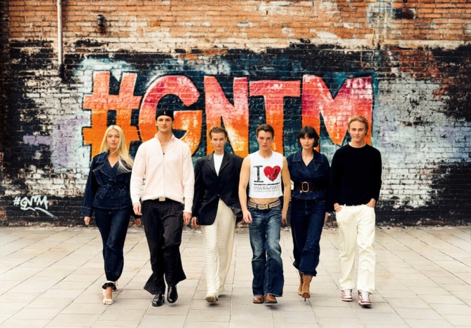 Die verbleiben 6 Finalist*innen stehen vor einer besprayten Wand