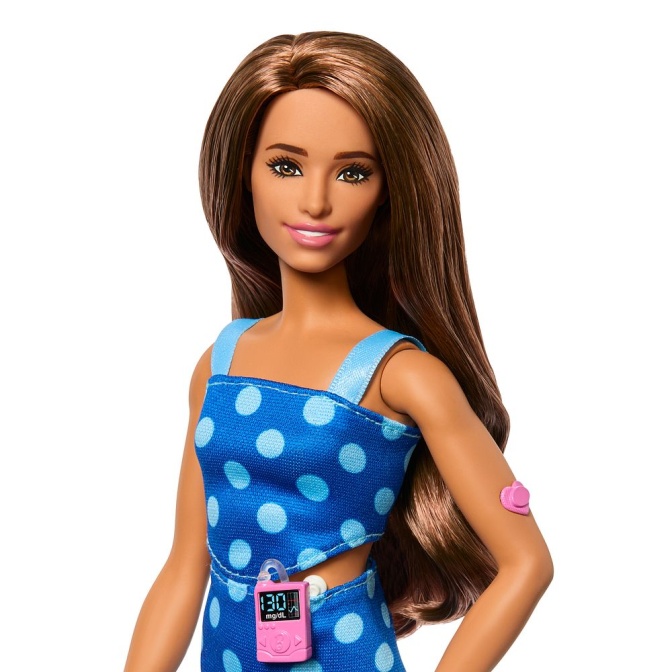 Eine Barbiepuppe in einem blau gemusterten Kleid mit einer rosafarbenen Insulinpumpe.