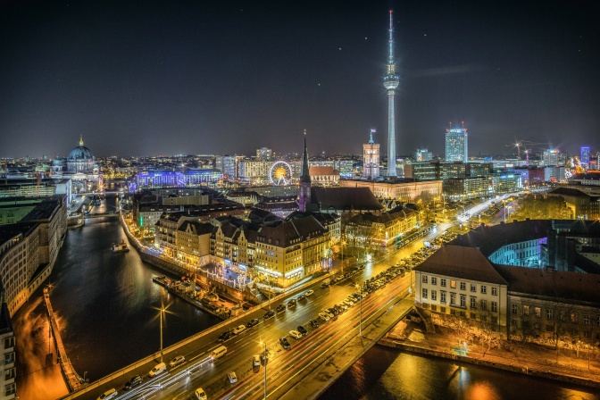 Berlin im Dunkeln von oben fotografiert. Man sieht Verkehrslichter.