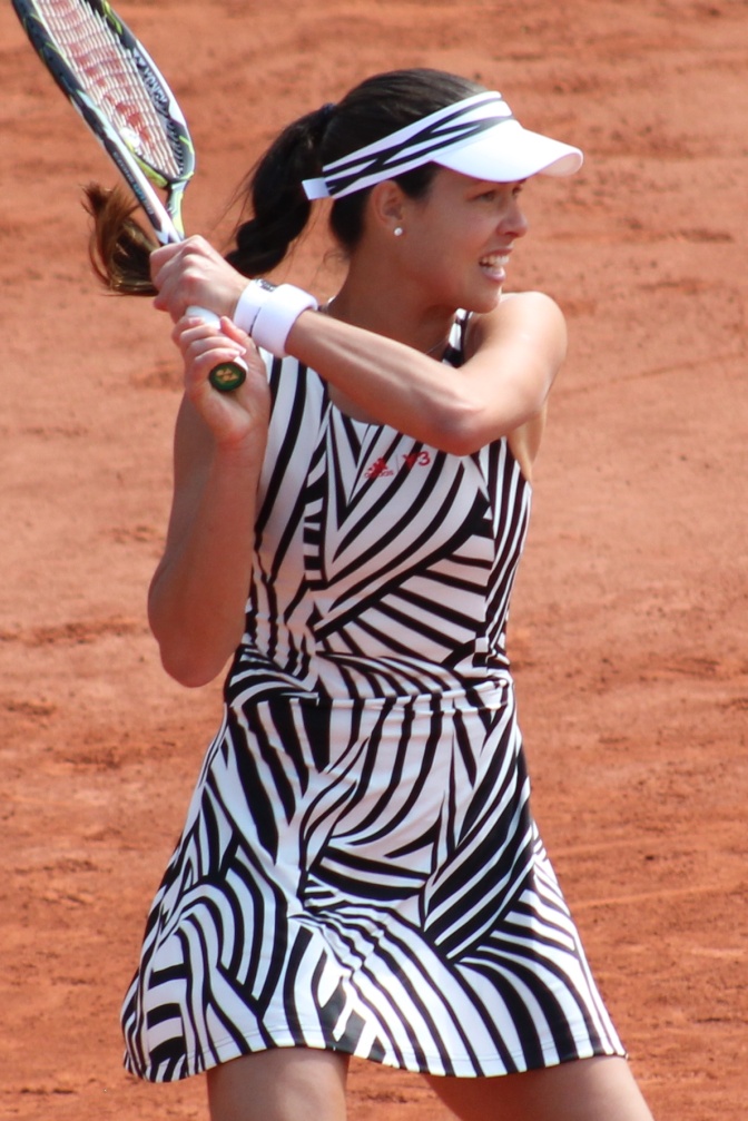 Ana Ivanović in einem Tenniskleid mit Zebramuster auf dem Tennisplatz. Sie hält den Schläger mit beiden Händen.