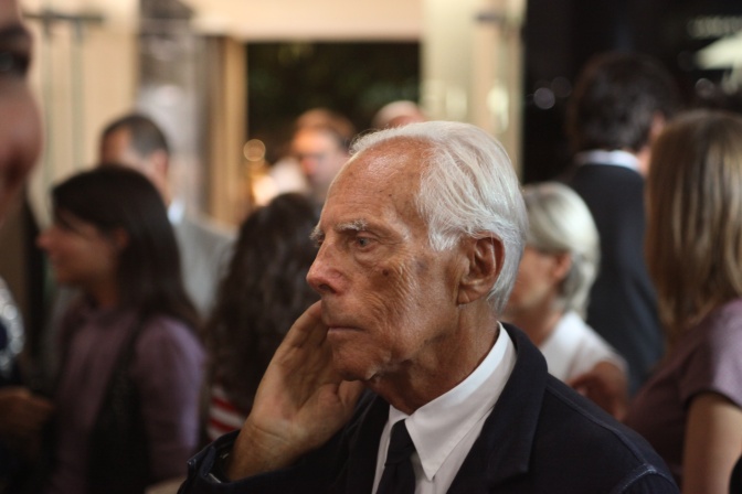 Giorgio Armani in Anzug und Hemd. Er hat weiße Haare und ist im Profil zu sehen.