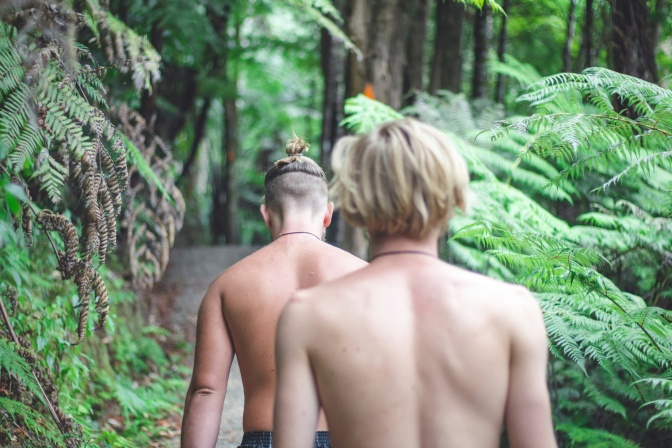 2 nackte Männer im Wald. Beide wurden von hinten fotografiert.