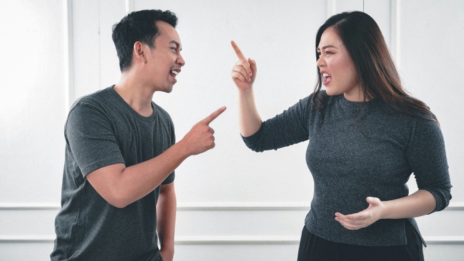 Ein heterosexuelles asiatisches Paar streitet sich und gestikuliert dabei.