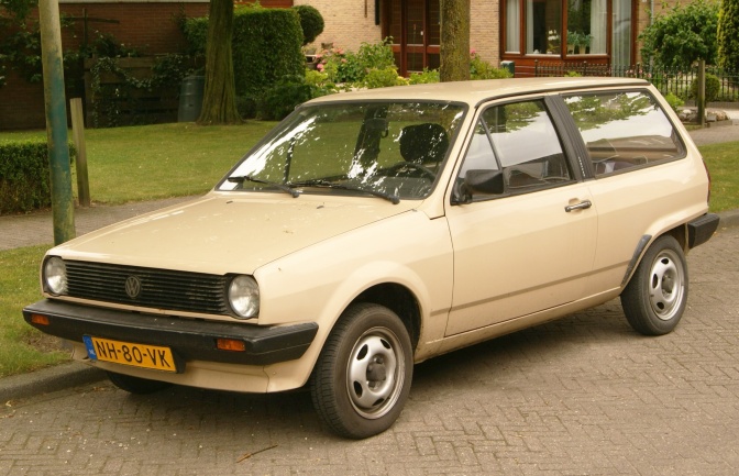 Ein beigefarbenes, kastiges Auto.