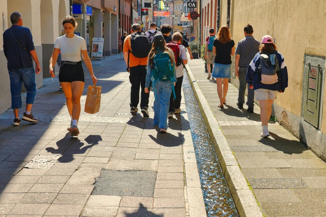 Menschen in sommerlicher Kleidung laufen durch die Innenstadt.