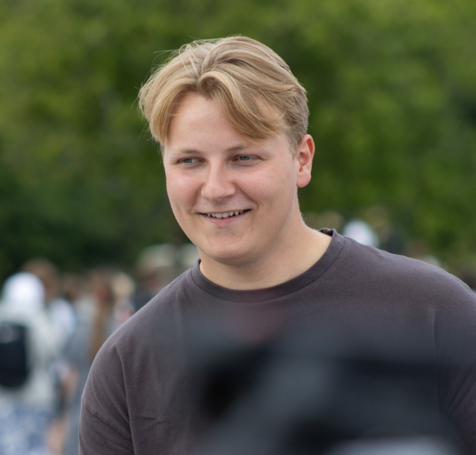 Sverre Magnus in einem blauen Sweatshirt. Er steht im Freien.