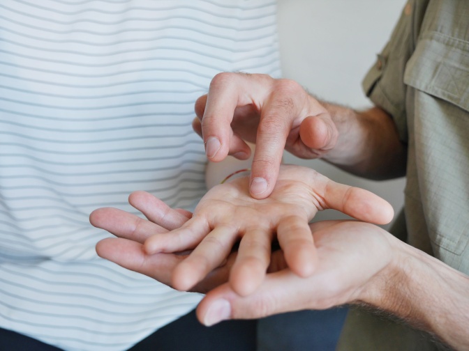 Eine Person lormt in der Handfläche einer anderen Person.