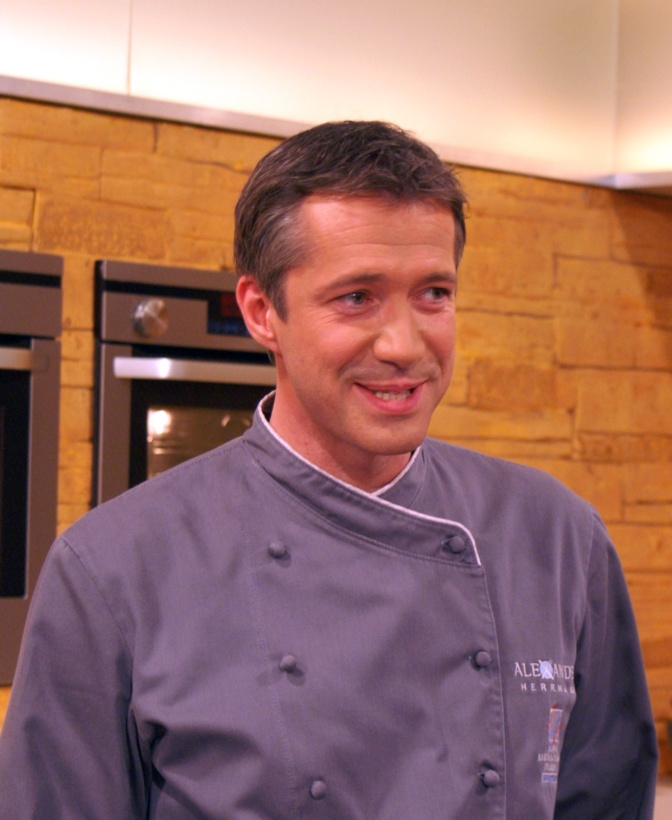 Alexander Herrmann in hellblauer Kochjacke.