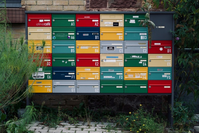 Viele bunte Briefkästen über- und nebeneinander.