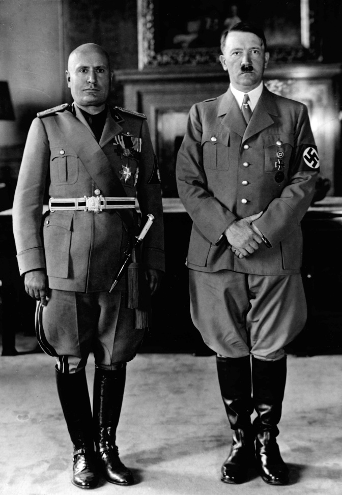 Ein schwarz-weiß-Foto von Adolf Hitler und Benito Mussolini, die in Uniform nebeneinander stehen.