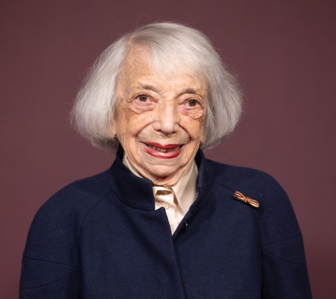 Margot Friedländer mit kinnlangen weißen Haaren in einem dunkelblauen Kostüm. Am Revers trägt sie das Bundesverdienstkreuz.