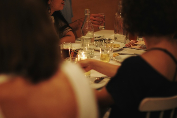2 Frauen sitzen an einem festlich gedeckten Tisch, Sie sind von hinten zu sehen.