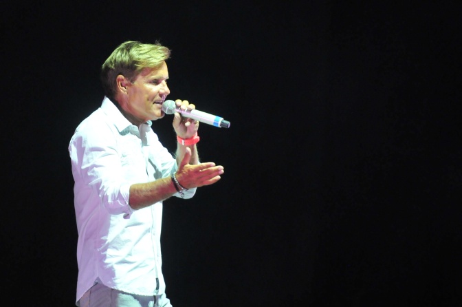 Dieter Bohlen in einem weißen Hemd auf der Bühne. Er singt in ein Mikro und gestikuliert mit der Hand.