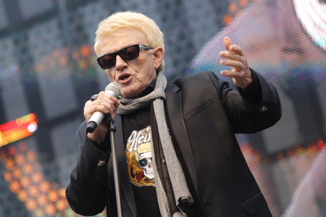 Heino mit schwarzer Sonnenbrille und in Lederjacke. Er singt in ein Mikro.