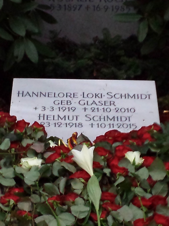 Ein Grabstein mit Lebensdaten und Namen von Helmut und Loki Schmidt. Auf dem Grab liegen weiße und rote Rosen.