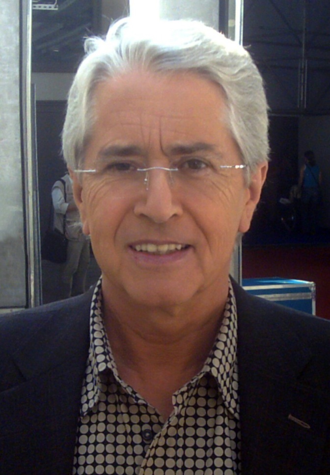 Frank Elstner mit weißen Haaren mit einer zurückhaltenden Brille in gepunkteten Hemd und Sakko