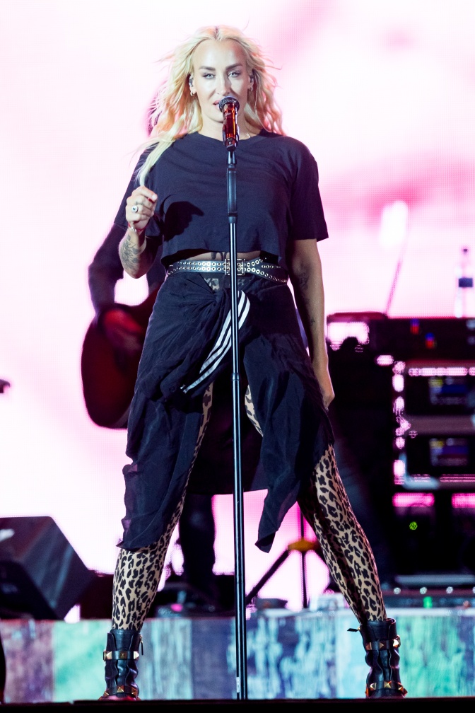 Sarah Connor auf der Bühne. Sie singt in ein Mikro, hinter ihr sieht man Verstärker.