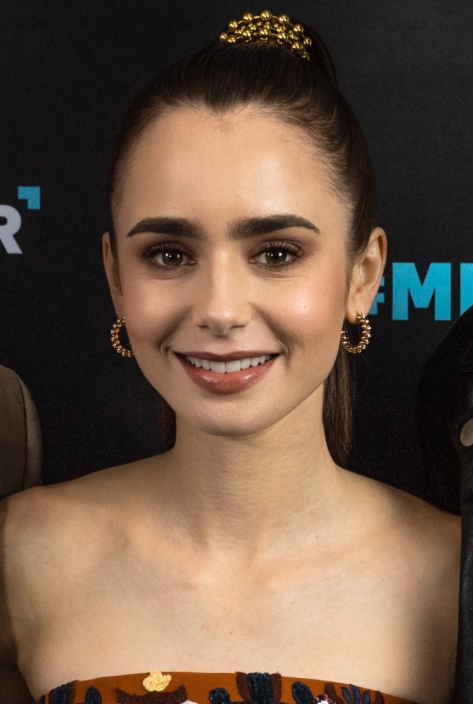 Lily Collins mit hochgesteckten Haaren in einem schulterfreien Oberteil.