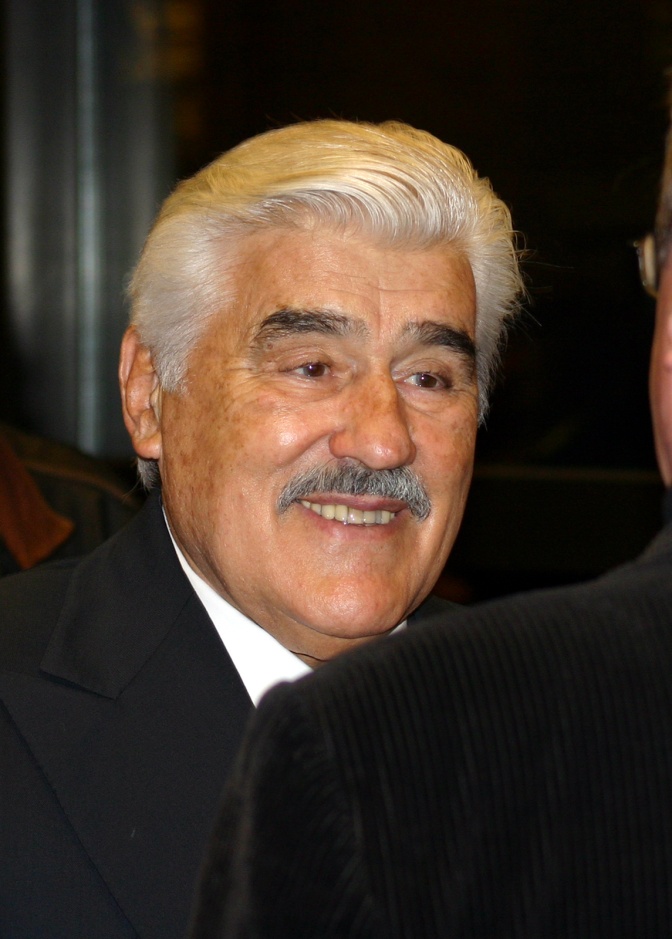 Mario Adorf mit weißen Haaren und Schnurrbart. Er ist im Gespräch und lächelt leicht.