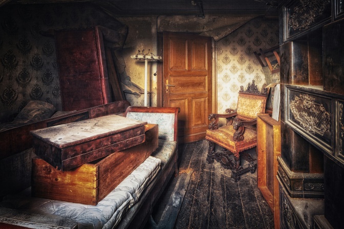 Ein verlassenes Zimmer mit staubigen Möbeln aus einer anderen Zeit.