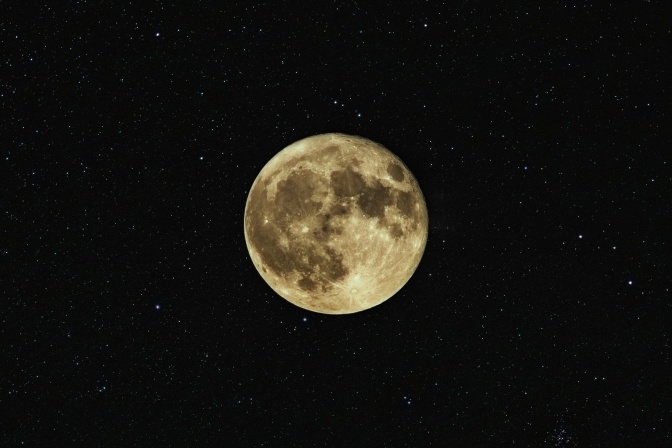 Vollmond vor einem Nachthimmel mit Sternen