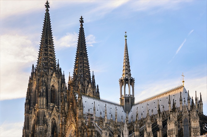 Außenansicht des Kölner Doms vor strahlend blauem Himmel.