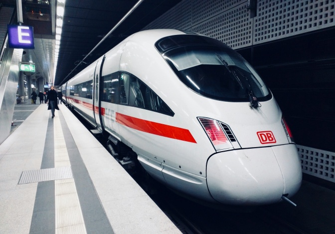 Ein rot-weißer ICE der deutschen Bahn steht am Gleis.