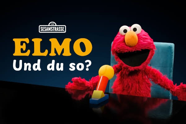 Elmo sitzt vor einem Mikrofon, daneben steht der Schriftzug Elmo und du so?