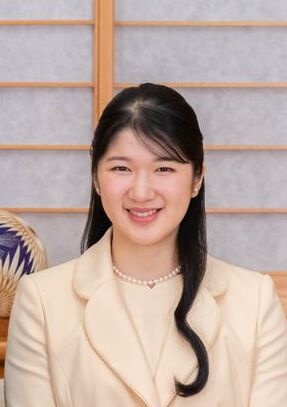Prinzessin Aiko in einem cremefarbenen Blazer. Sie hat schwarze, zu Teilen zurückgebundene lange Haare und lächelt in die Kamera.