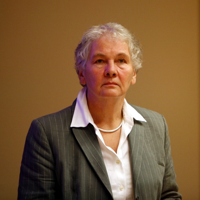Christiane Nüsslein-Volhard in einem grauen Sakko mit weißer Bluse. Sie hat kurze, graue Haare und schaut ernst in die Kamera.