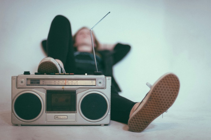 Eine Frau liegt auf dem Boden, vor ihr steht ein Radio.