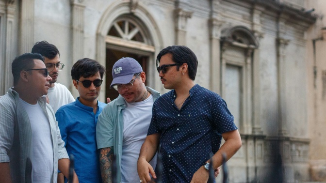 Eine Gruppe junger, asiatischer Männer steht im Gespräch zusammen.