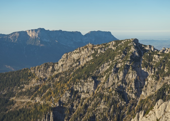 Das Gebäude steht frei auf einem hohen Berg, dahinter weitere Berge.
