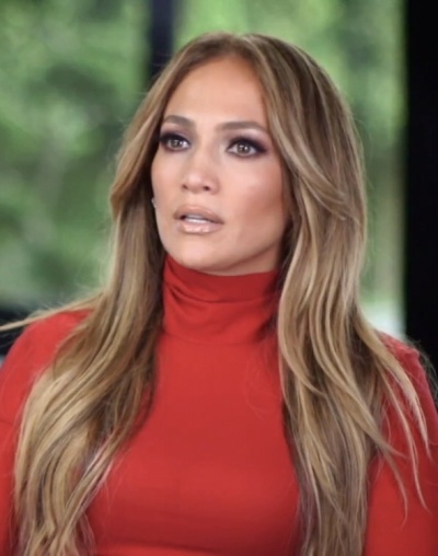 Jennifer Lopez mit langen, glatten dunkelblonden Haaren in einem roten Rollkragenpullover.