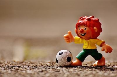 Eine Pumuckl-Figur aus Plastik mit einem Fußball